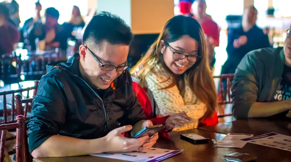 Players answering Taunt questions on their phones at a watch party.
